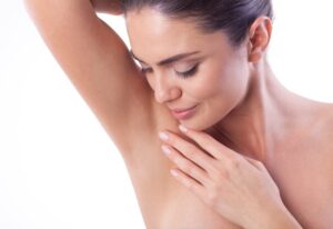 Woman showcasing laser hair removal under armpit
