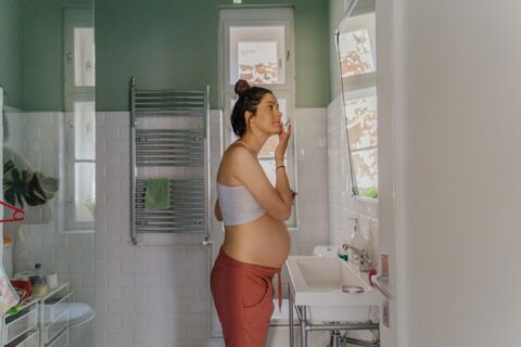 A pregnant woman is providing herself a skincare in Dallas, TX, and surrounding area